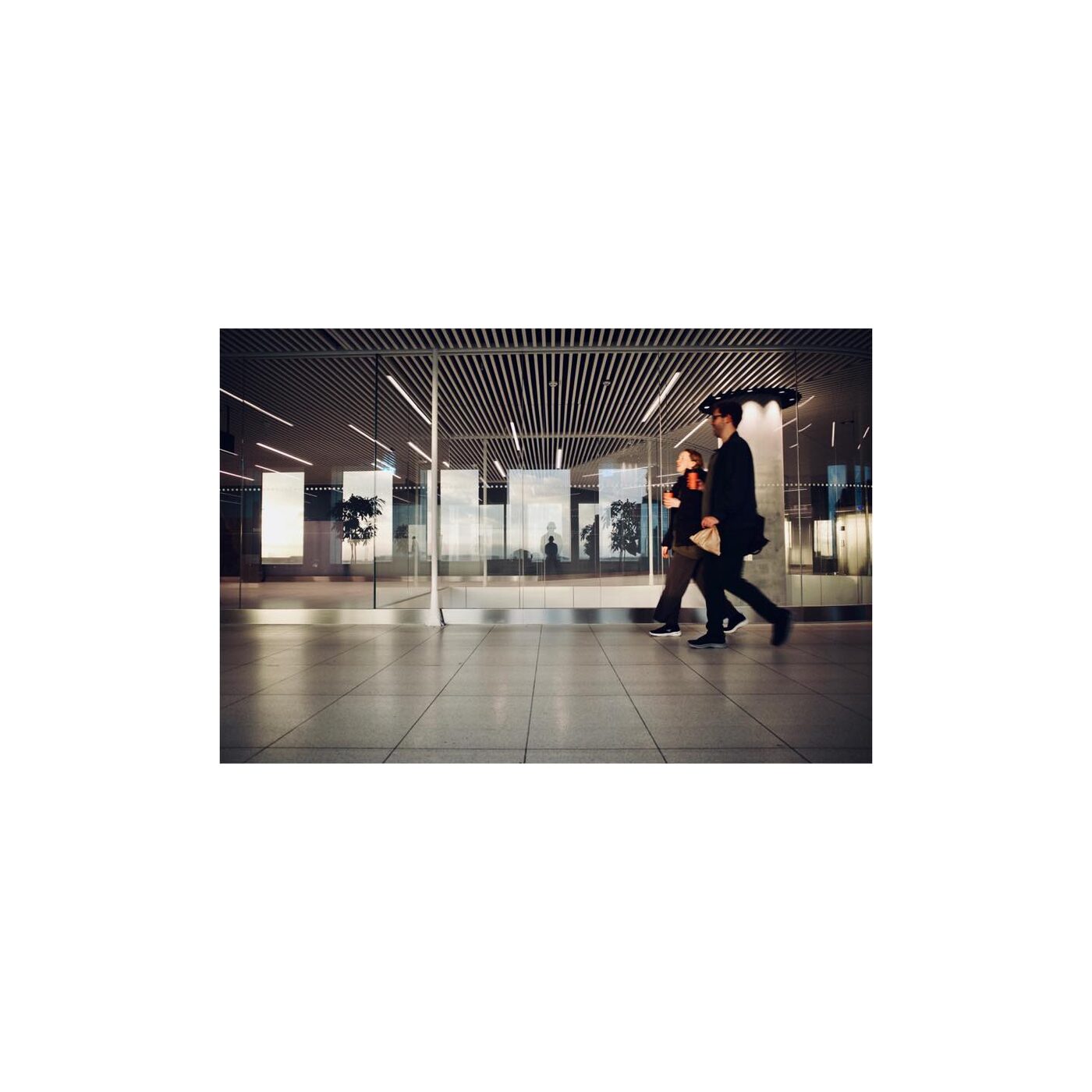 Blurred figures walking through a station corridor