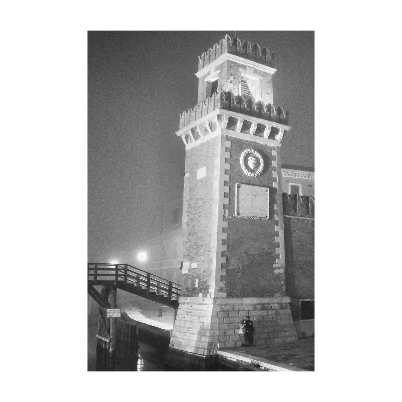 A clock tower emerging from fog, black and white
