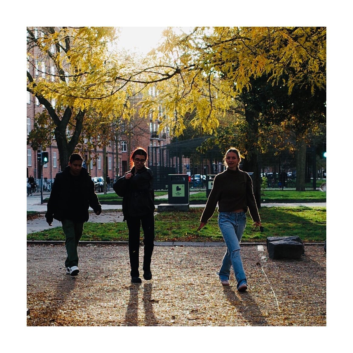 Three people walking through an autumn park