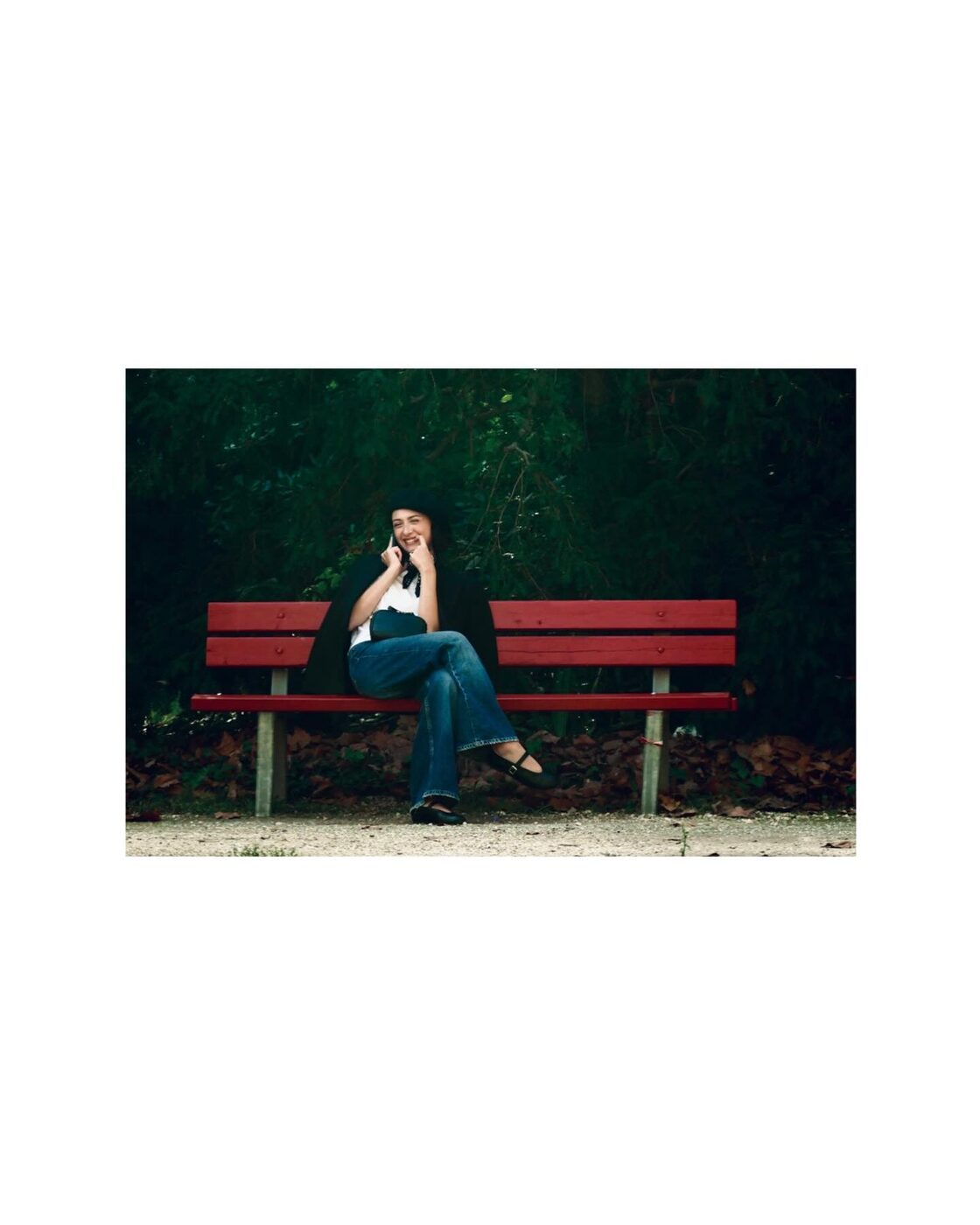 A woman sitting alone on a red bench