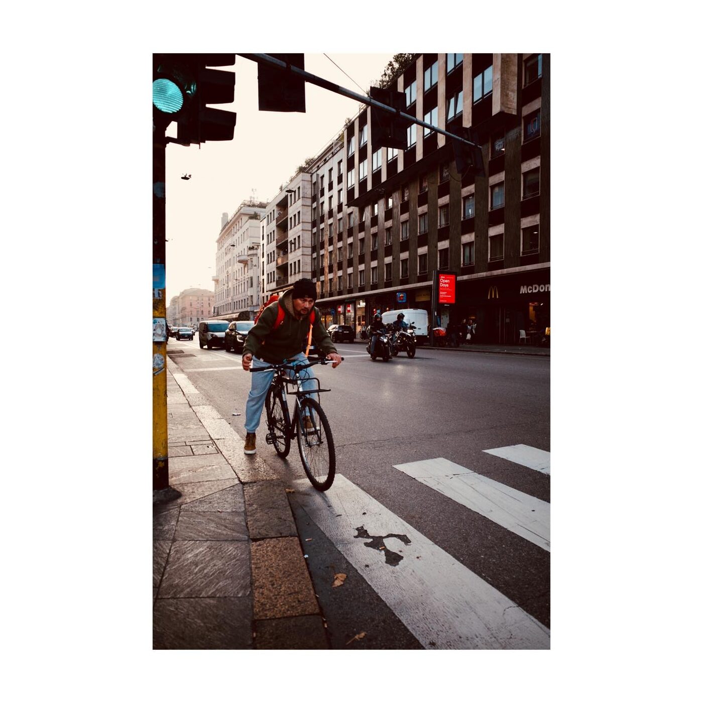 A cyclist crossing a sunny crosswalk