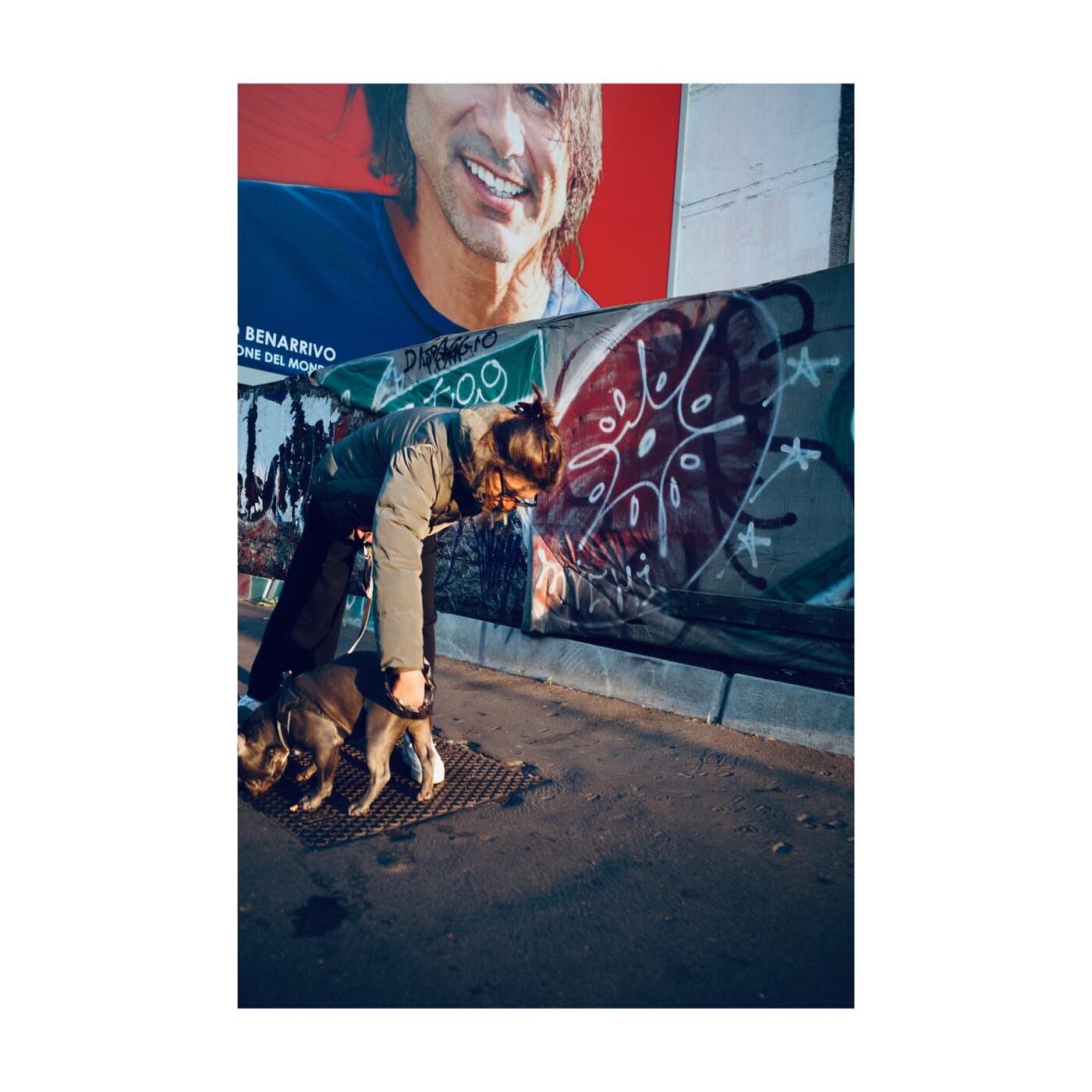 A couple walking arm in arm past a colorful mural