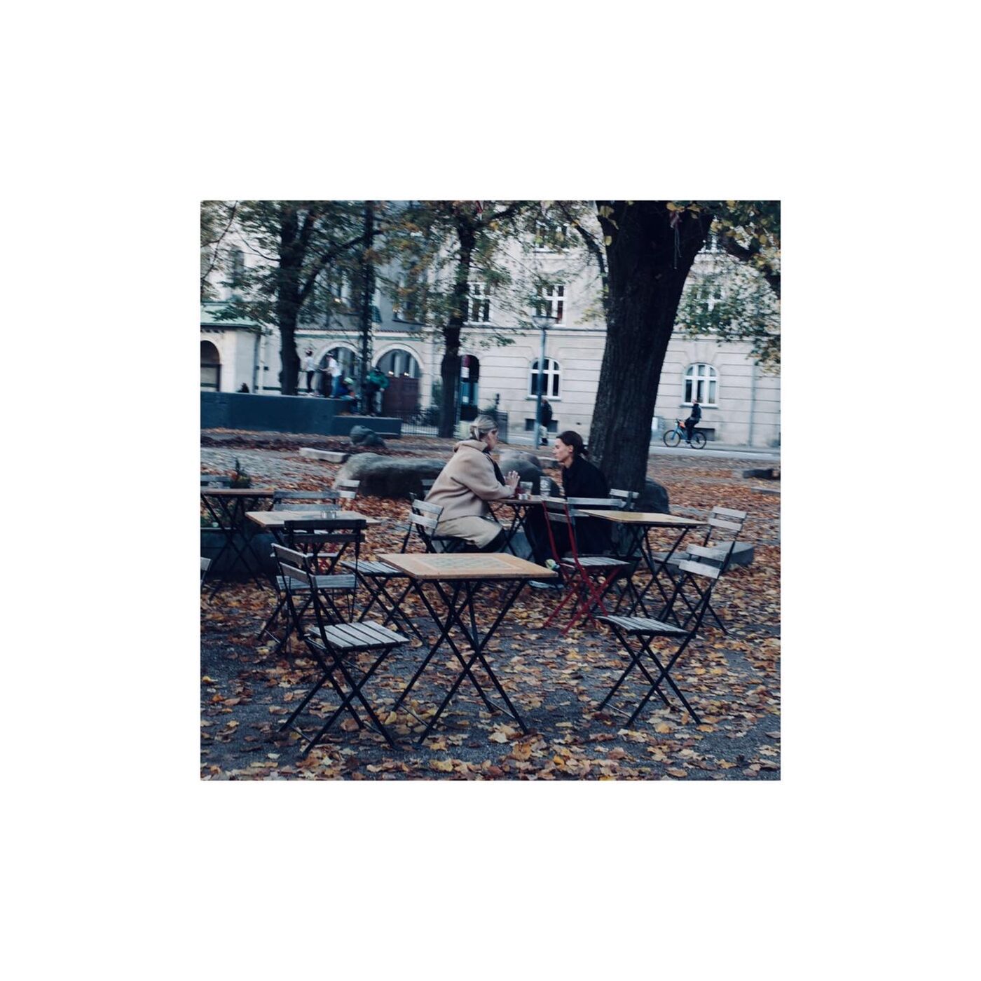 Empty outdoor cafe tables among trees