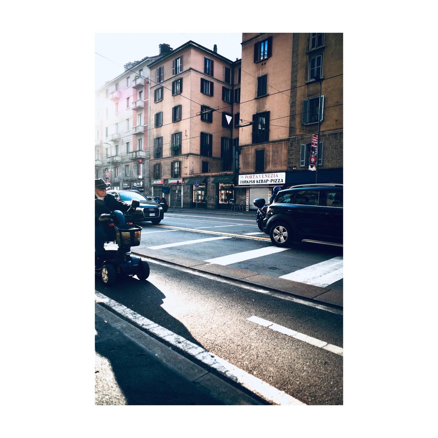 City buildings and cars at a crosswalk in evening light