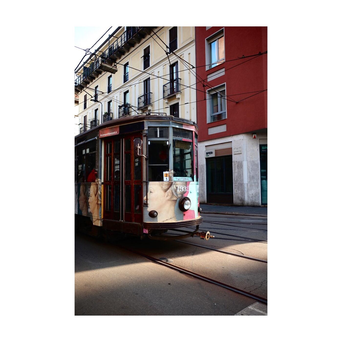 A vintage tram on a red-brick street